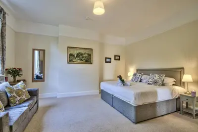 a bedroom with a bed and a couch at Harkstead Hall By Group Retreats in Ipswich
