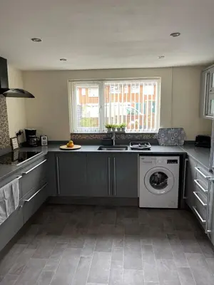 a kitchen with a sink and a washing machine at Sea Breeze in Harwich