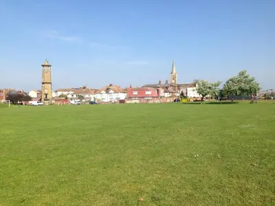 a large green field with a town in the background at Tidal Walk in Harwich