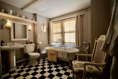 a bathroom with a tub and a toilet and a sink at The Cottage at Barkwith House in Leiston
