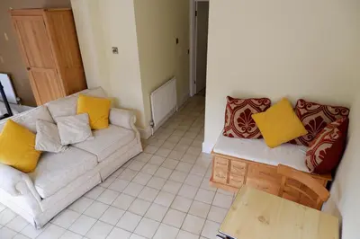 a living room with a couch and a table at Colchester Sunny Apartment with Pool and EV Car Point in Lexden