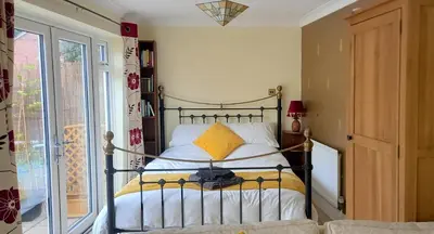 a bedroom with a bed with a yellow pillow at Colchester Sunny Apartment with Pool and EV Car Point in Lexden