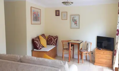 a living room with a couch and a table at Colchester Sunny Apartment with Pool and EV Car Point in Lexden