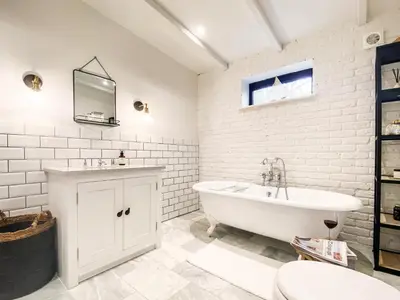 a white bathroom with a tub and a sink at Little Owl by The Suffolk Cottage Collection in Aldeburgh