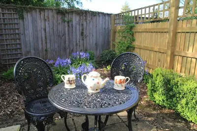 a table with three tea sets on it in a garden at 1 Bed in Debenham oc-glah in Worlingworth