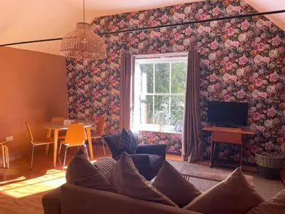 a living room with a couch and a window at Top House -Stylish property in village location in Bildeston
