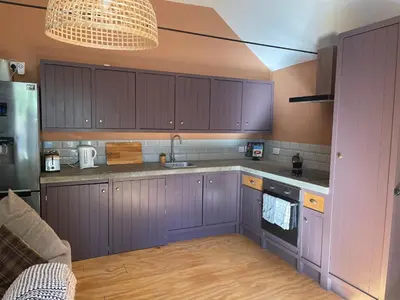 a kitchen with purple cabinets and a sink at Top House -Stylish property in village location in Bildeston