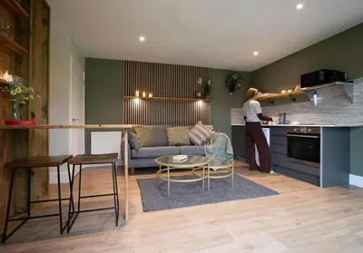 a woman standing in the kitchen of a living room at City to Country Retreat Luxury Lodges with Hot Tub, BBQ, Fire Pit in Toppesfield