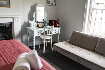 a bedroom with a desk and a bed with a couch at The Old Cannon Brewery in Bury Saint Edmunds