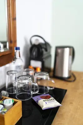 a counter top with glasses and a box on it at The Old Cannon Brewery in Bury Saint Edmunds