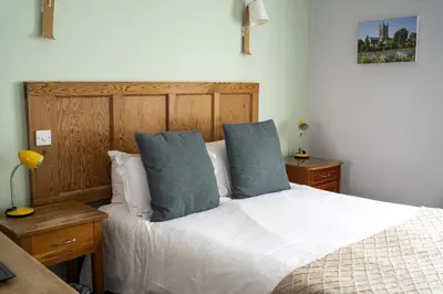 a bedroom with a white bed with two blue pillows at The Old Cannon Brewery in Bury Saint Edmunds