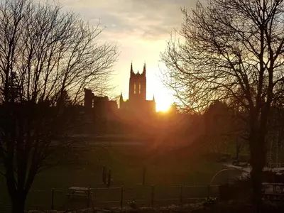 a building with a clock tower in the sunset at The Old Cannon Brewery in Bury Saint Edmunds