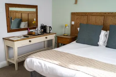 a bedroom with two beds and a desk with a mirror at The Old Cannon Brewery in Bury Saint Edmunds