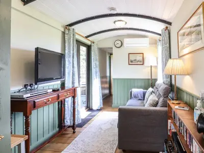 a living room with a couch and a tv at The Brake Wagon at High Barn Heritage in Halstead