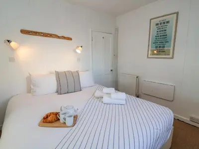 a white bed with a tray of food on it at Valetta, Thorpeness in Thorpeness