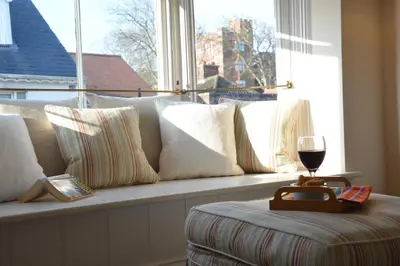 a window seat with a couch with a glass of wine at The Hideaway, Aldeburgh in Aldeburgh