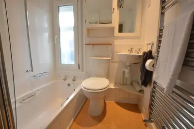 a bathroom with a toilet and a tub and a sink at Crabbe House in Aldeburgh