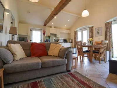 a living room with a couch and a kitchen at Romulus in Roudham
