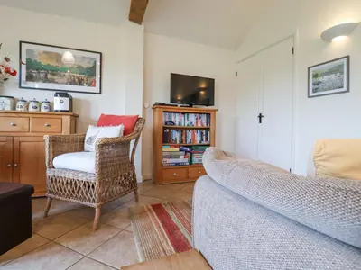 a living room with a couch and a chair and a tv at Romulus in Roudham