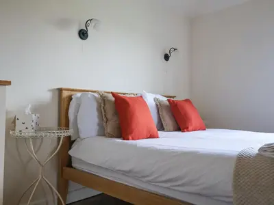 a bedroom with a bed with red pillows at Romulus in Roudham