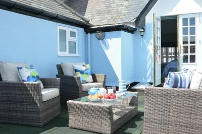 a patio with wicker chairs and a table with fruit on it at Bunny Cottage, Aldeburgh in Aldeburgh