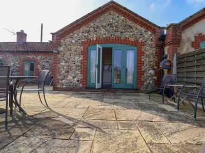 a patio with chairs and a door to a building at Remus in Larling