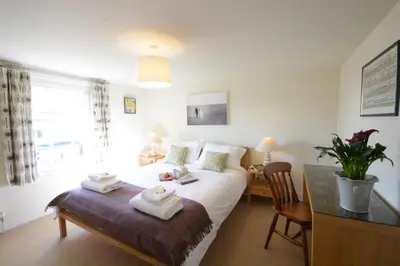 a bedroom with a bed with towels on it at Pebble Beach Cottage, Aldeburgh in Aldeburgh