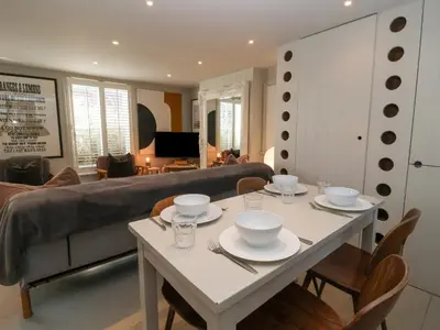 a living room with a table and a couch at Mariners Cottage in Aldeburgh