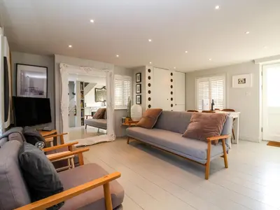 a living room with a couch and a television at Mariners Cottage in Aldeburgh