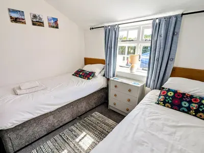 a bedroom with two beds and a window at 1 Grange Cottages, Westleton in Westleton