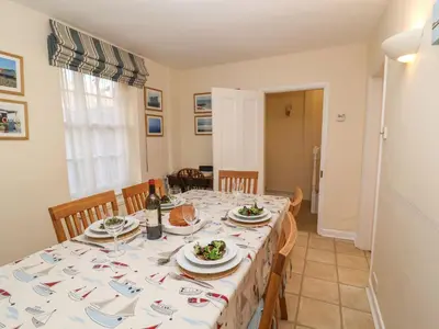 a dining room with a table with plates of food on it at Winkle Cottage, Aldeburgh in Aldeburgh