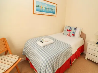 a small bedroom with a bed and a dresser at Winkle Cottage, Aldeburgh in Aldeburgh