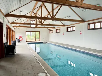 a large swimming pool in a large room with at Saffron, Blythview in Blythburgh