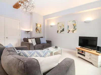a living room with a couch and a tv at Saffron, Blythview in Blythburgh