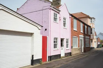 a row of pink houses on a street at Alinka, Aldeburgh in Aldeburgh