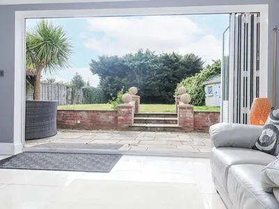 a living room with a couch and a patio at Little Wissett, Aldeburgh in Aldeburgh