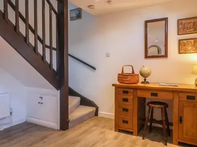 a room with a desk and a staircase with a stool at Pine Cottage in Woodbridge