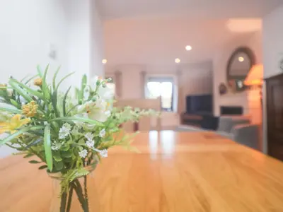 a vase with flowers on a table in a living room at Pine Cottage in Woodbridge