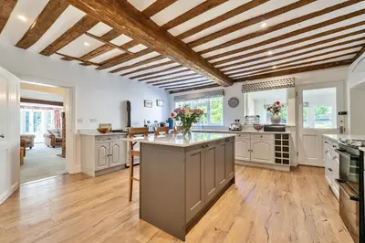 a large kitchen with wooden ceilings and a large center island at Bedingfield House, nr Debenham in Debenham