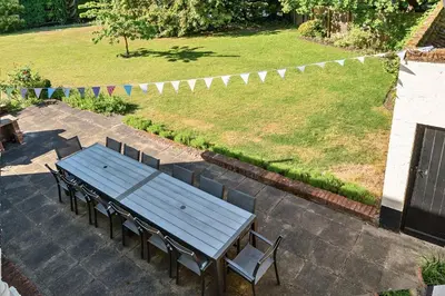 a picnic table and chairs on a patio with a lawn at Bedingfield House, nr Debenham in Debenham