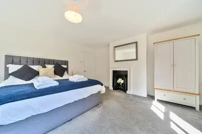 a bedroom with a large bed and a fireplace at Bedingfield House, nr Debenham in Debenham