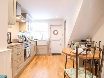 a kitchen with a wooden table and a dining room at 51 Tern Cottage, Aldeburgh in Aldeburgh
