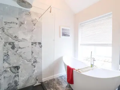 a bathroom with a white tub and a shower at 51 Tern Cottage, Aldeburgh in Aldeburgh