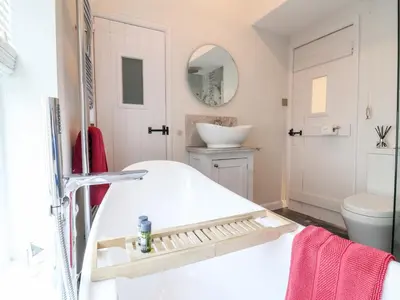 a white bathroom with a sink and a toilet at 51 Tern Cottage, Aldeburgh in Aldeburgh