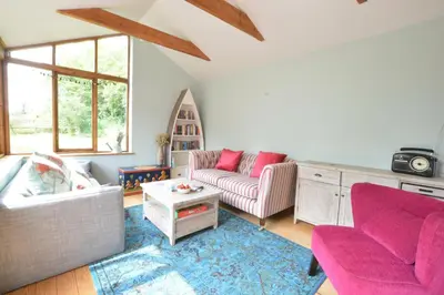 a living room with two couches and a table at The White House with Studio in Homersfield