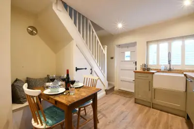 a kitchen and dining room with a table and a sink at Smugglers Rest, Aldeburgh in Aldeburgh