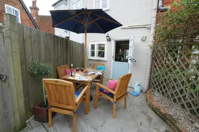 a table and chairs with an umbrella on a patio at Smugglers Rest, Aldeburgh in Aldeburgh