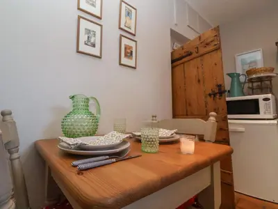 a kitchen with a wooden table with a green vase on it at Rosemary Cottage, Aldeburgh in Aldeburgh