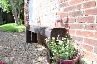 a brick wall with a flower pot next to a building at Rosemary Cottage, Aldeburgh in Aldeburgh