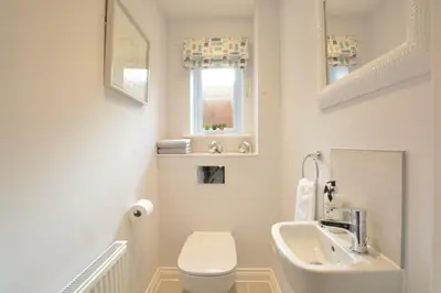a white bathroom with a sink and a toilet at Lapwings, Aldeburgh in Aldeburgh